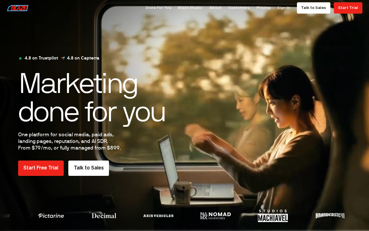 Головна сторінка Blaze з заголовком "Marketing done for you" та жінкою, що працює в потязі.